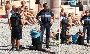 Police patrolling the promenade des anglais beach in Nice fine a woman for wearing a burkini. 23 August 2016. Please byline: Vantagenews.com