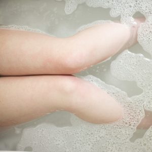 High angle view of legs of woman soaking in bathtub