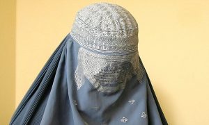 An Afghan woman wearing the traditional burqa casts her ballot at a polling station in Kabul